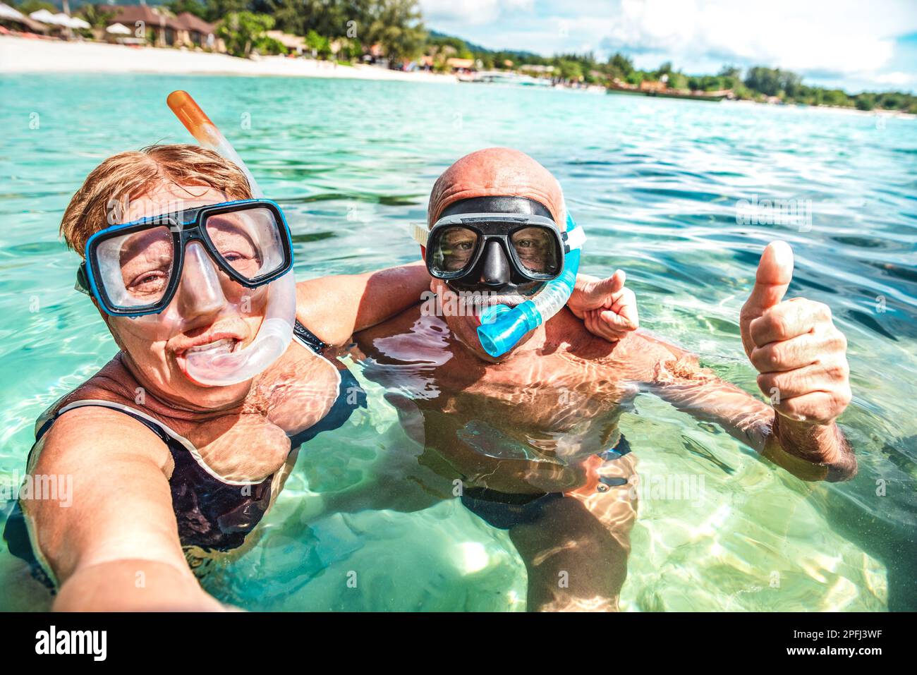 Seniorenpaar, das ein glückliches Selfie auf einem tropischen Meeresausflug mit Wasserkamera macht - Schnorchelkonzept für Bootsausflüge in exotischen Szenarien - aktives Leben im Ruhestand Stockfoto