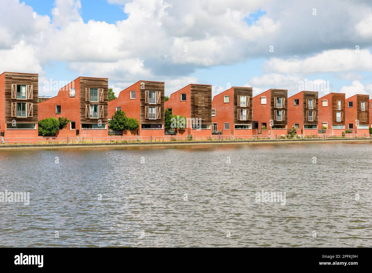 Eine Reihe moderner Einfamilienhäuser in einem Wohnungsbau an einem bewölkten Sommertag Stockfoto