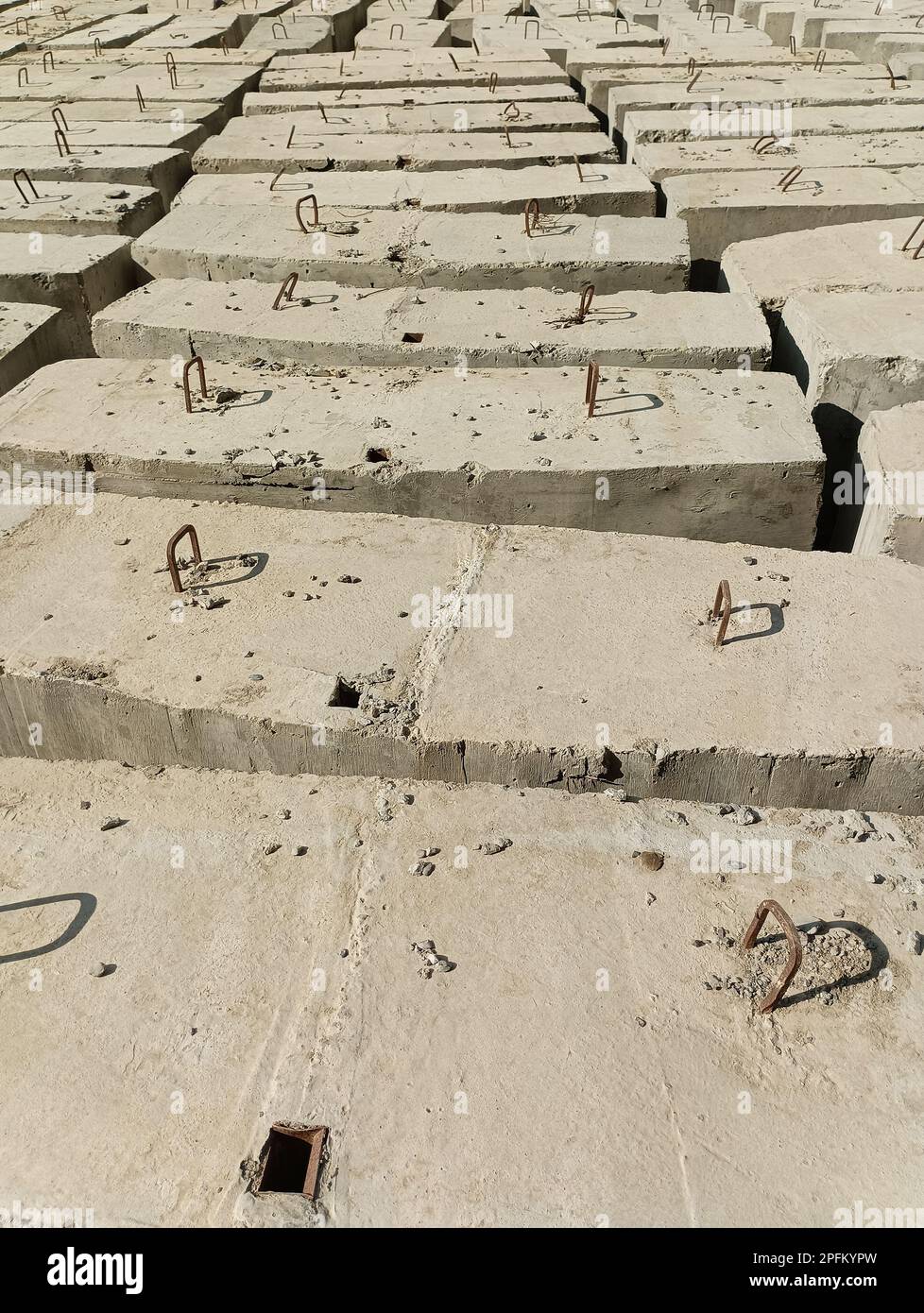 Zementblöcke mit Metallhaken auf der Baustelle Stockfoto