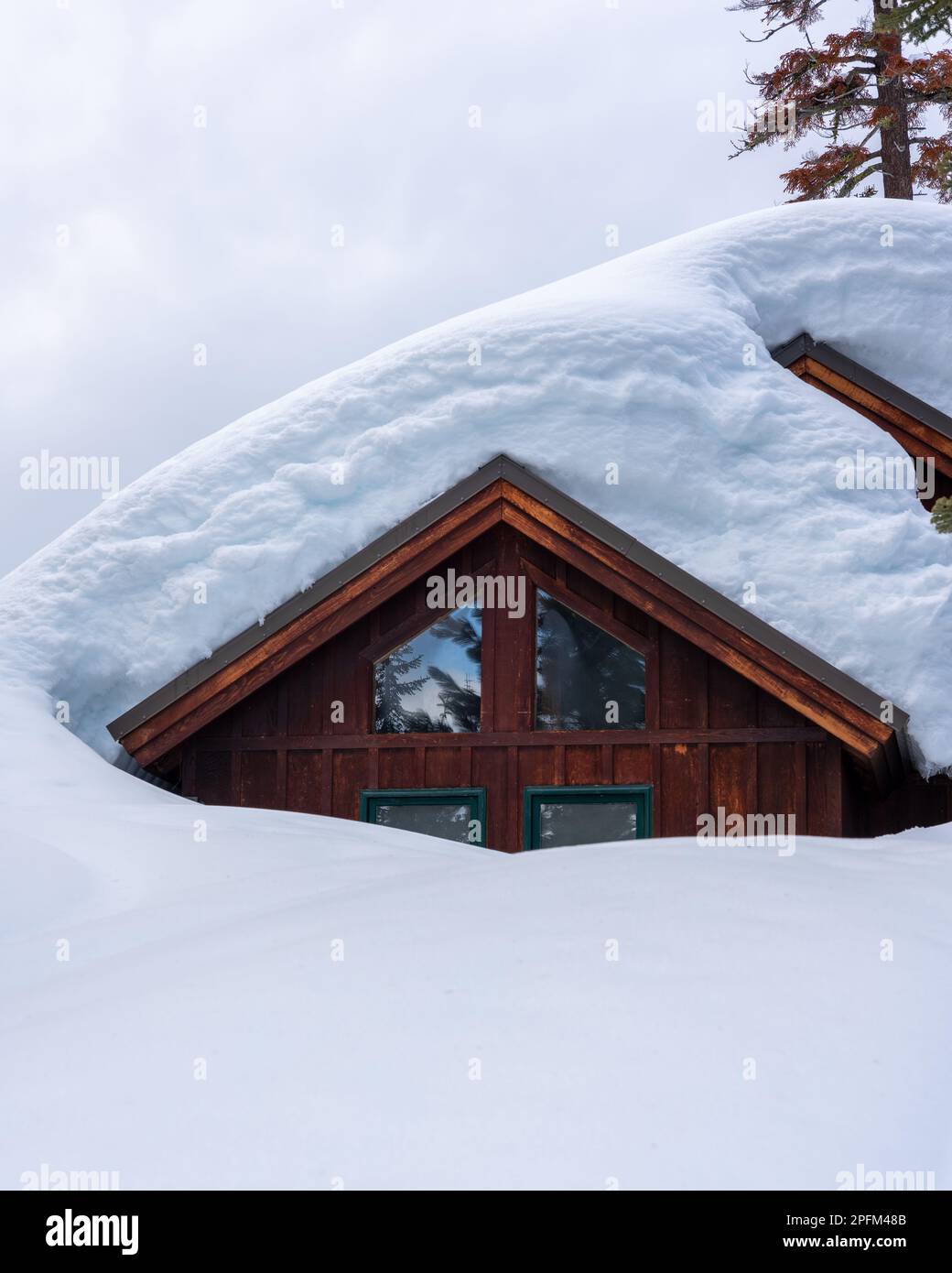 Eine Berghütte unter historischen Schneepegeln in Bear Valley, Kalifornien. Stockfoto