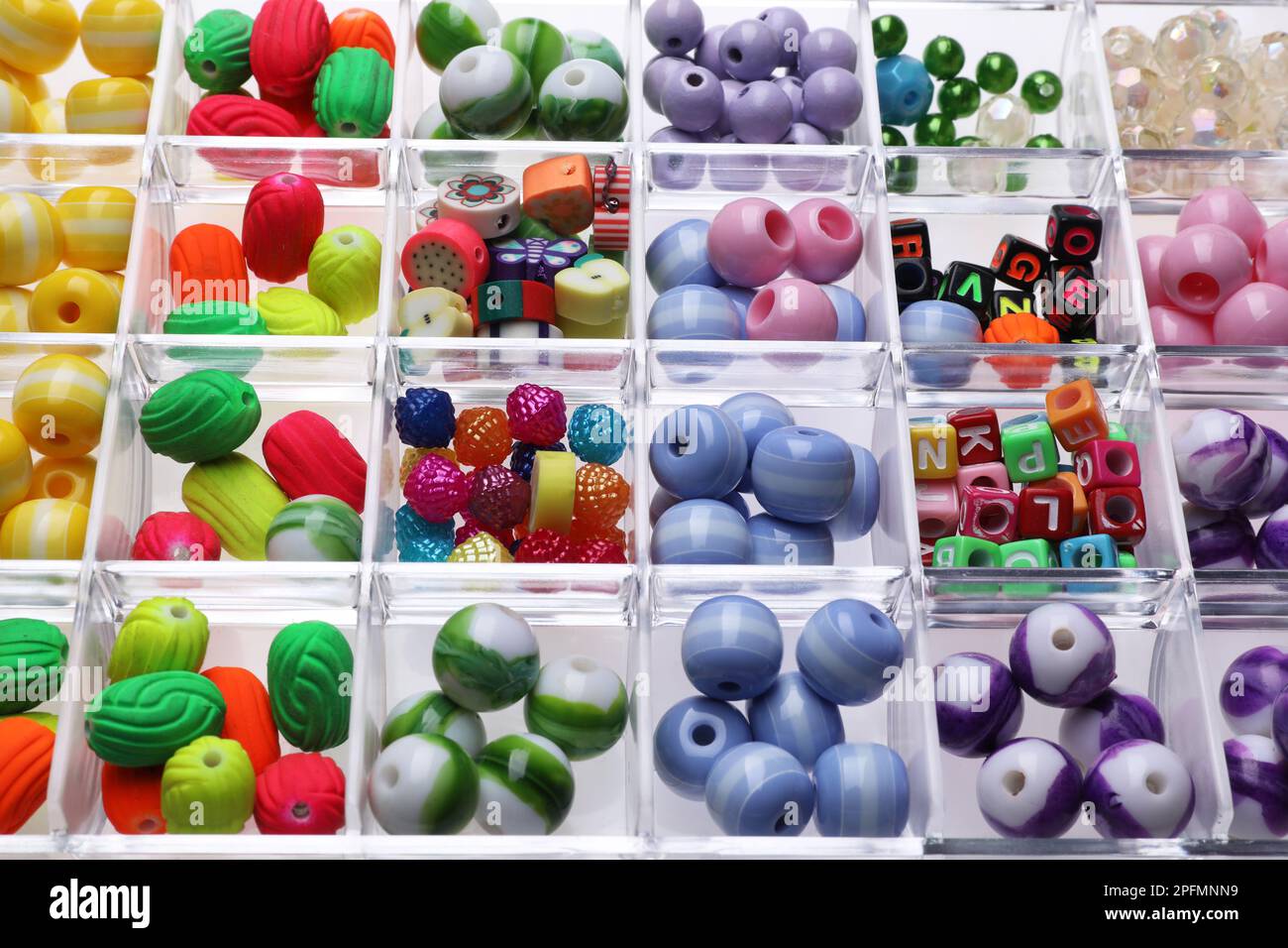Plastik-Organizer mit verschiedenen Perlen als Hintergrund, Nahaufnahme Stockfoto