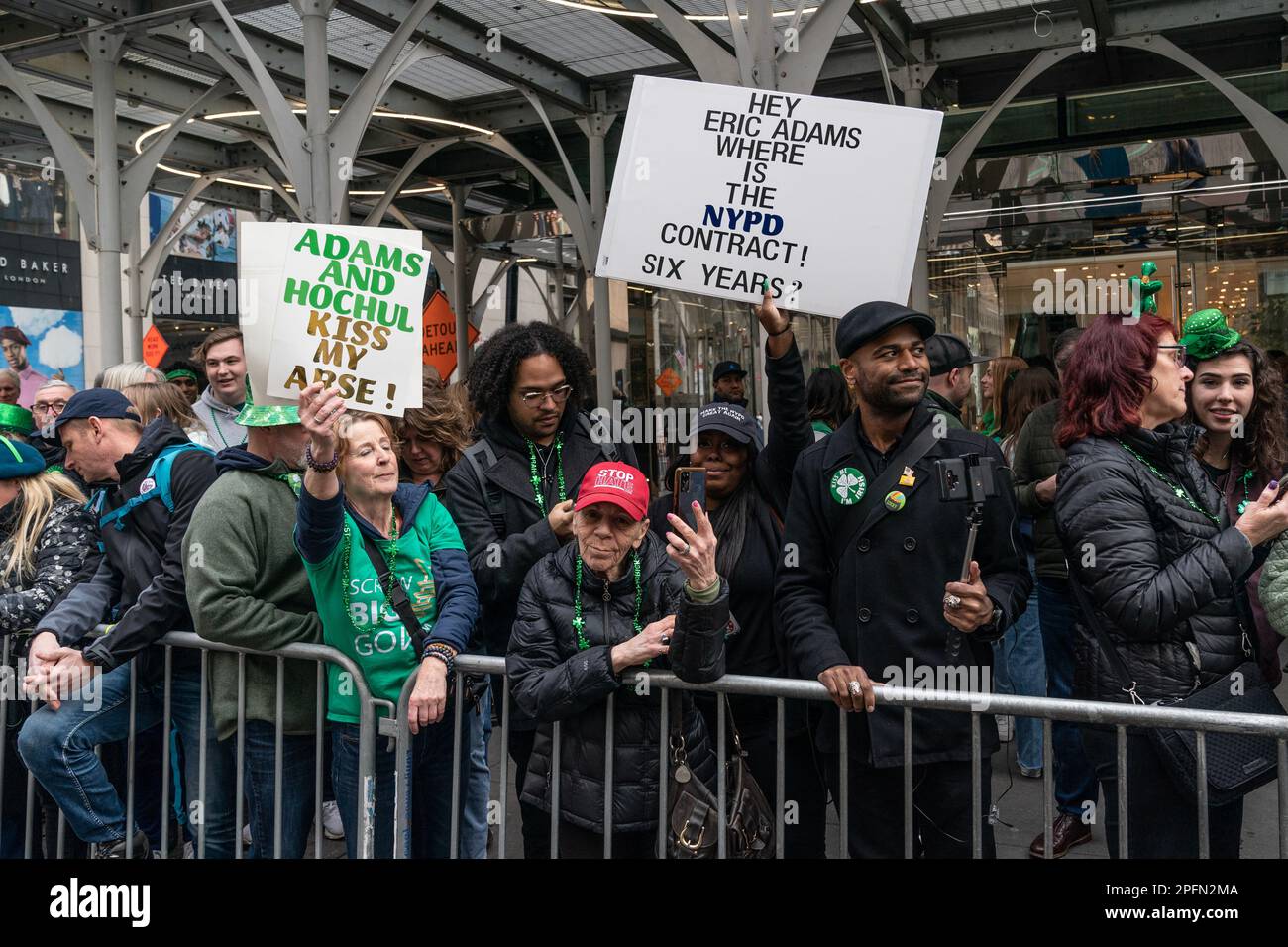 Einige Zuschauer halten Poster, auf denen Gewerkschaftsverträge für Polizeibeamte gefordert werden, während der jährlichen St. Patrick's Day Parade auf der 5. Avenue in New York am 17. März 2023 Stockfoto