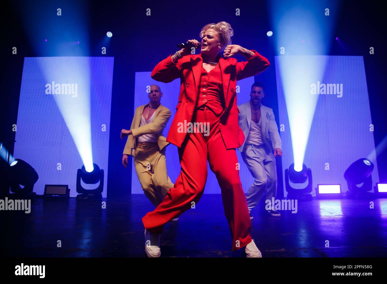 Toronto, Kanada. 17. März 2023. Die australisch-amerikanische Sängerin Betty tritt in einem roten Anzug mit Mikrofon auf der Bühne auf, flankiert von zwei männlichen Tänzern Credit: Bobby Singh/Alamy Live News Stockfoto