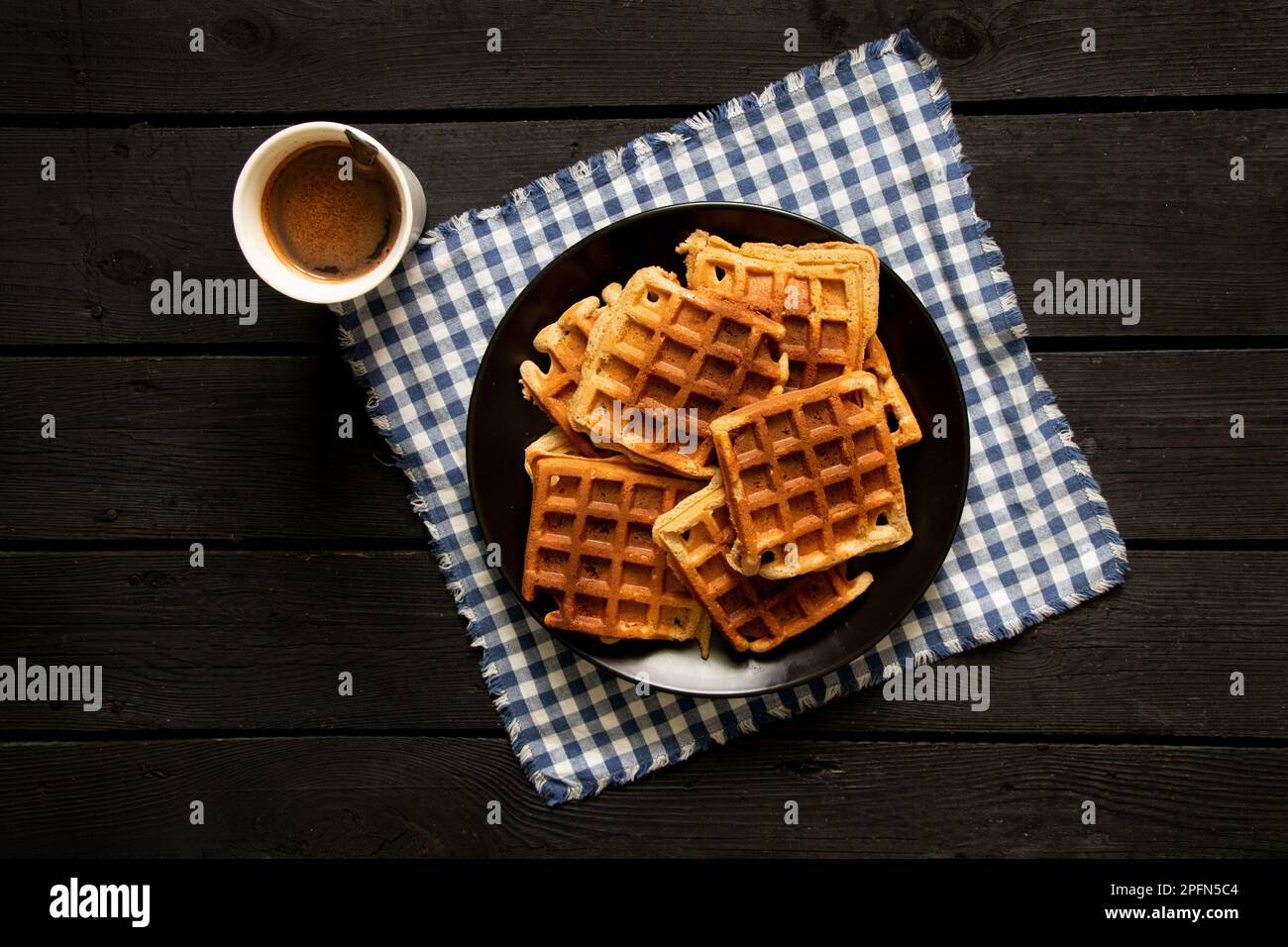 Wiener Waffel auf einem Holztisch und eine Tasse Kaffee, Waffeln zum Frühstück in der Küche zu Hause Stockfoto