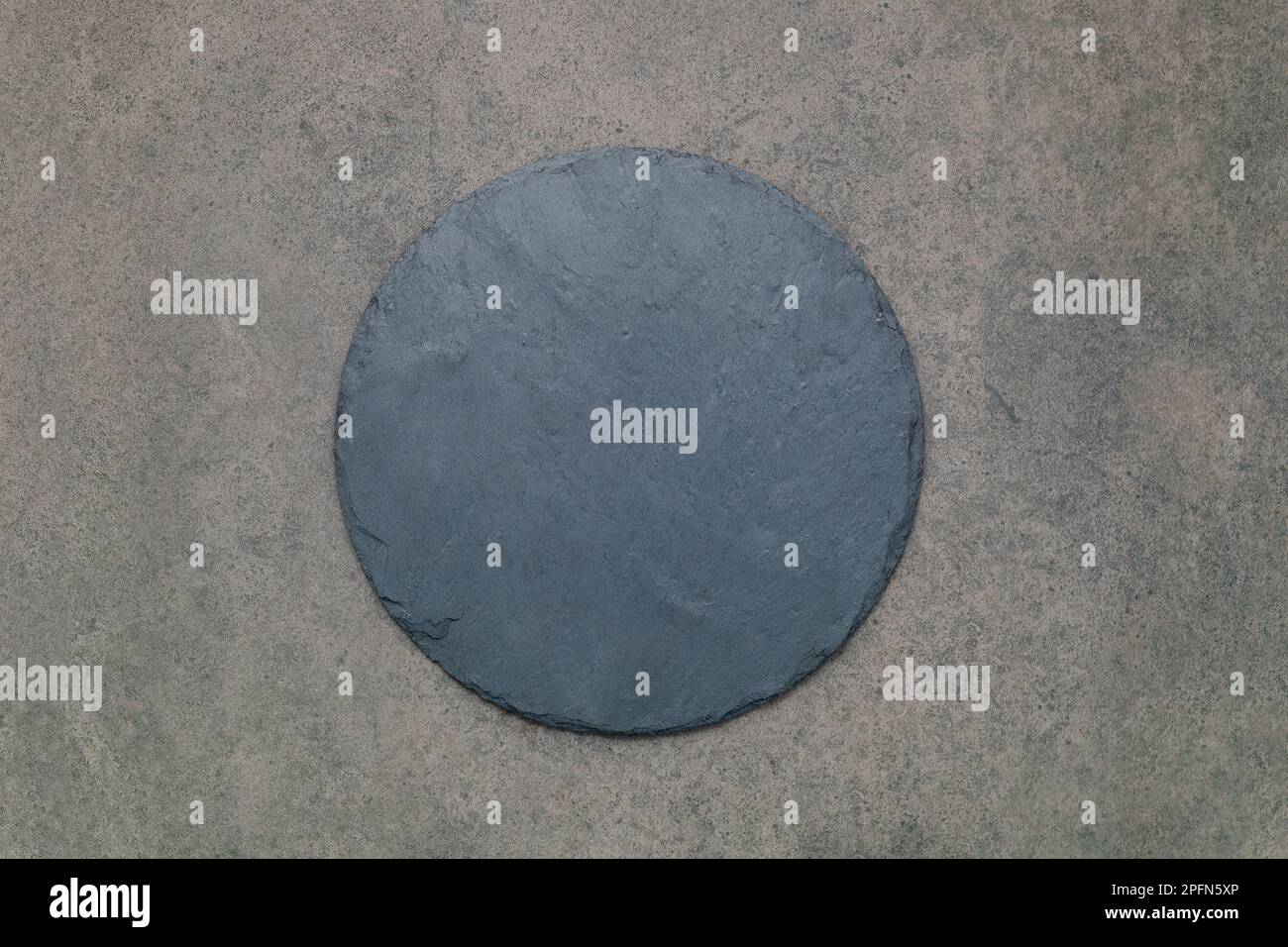 Leere Pizzaplatte für selbstgebackenes Backen auf dunklem Beton aufgesetzt. Food Rezept Konzept auf dunklen Stein Hintergrund Textur mit Kopierraum. Stockfoto