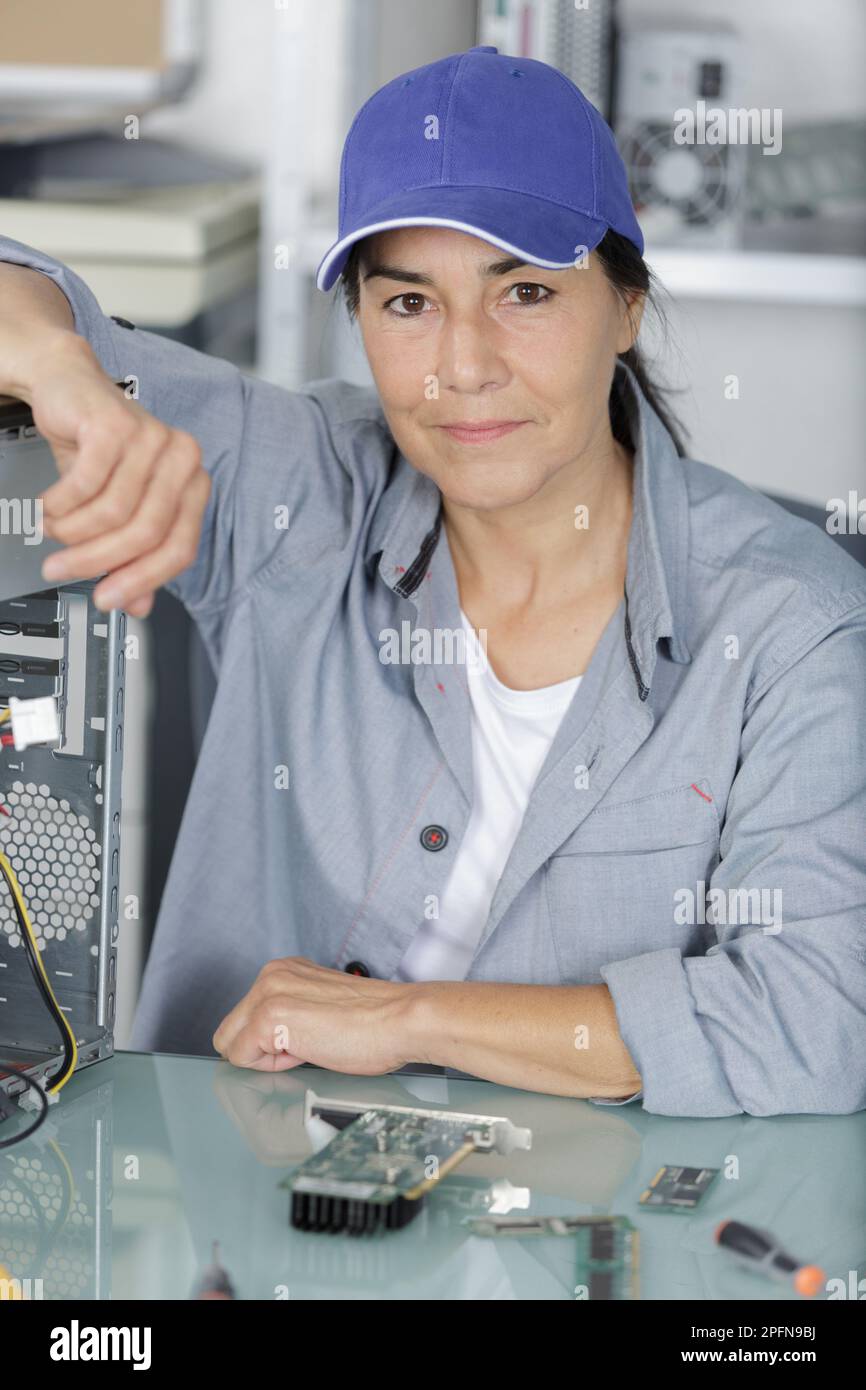 Attraktive lächelnde digitale Elektronikingenieurin, die auf die Kamera schaut Stockfoto