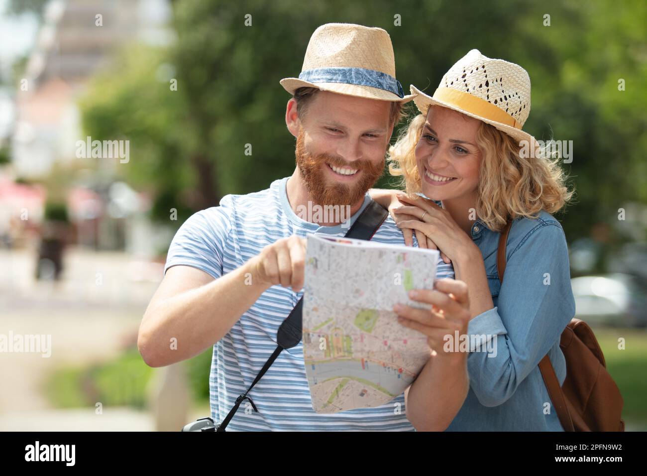 Lächelndes Paar, das im Urlaub auf die Karte schaut Stockfoto