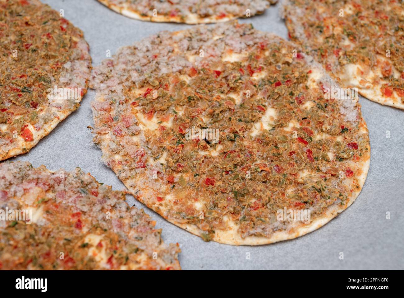 Verzehrfertiger gefrorener Lahmacun auf Backpapier auf einem Backblech Stockfoto