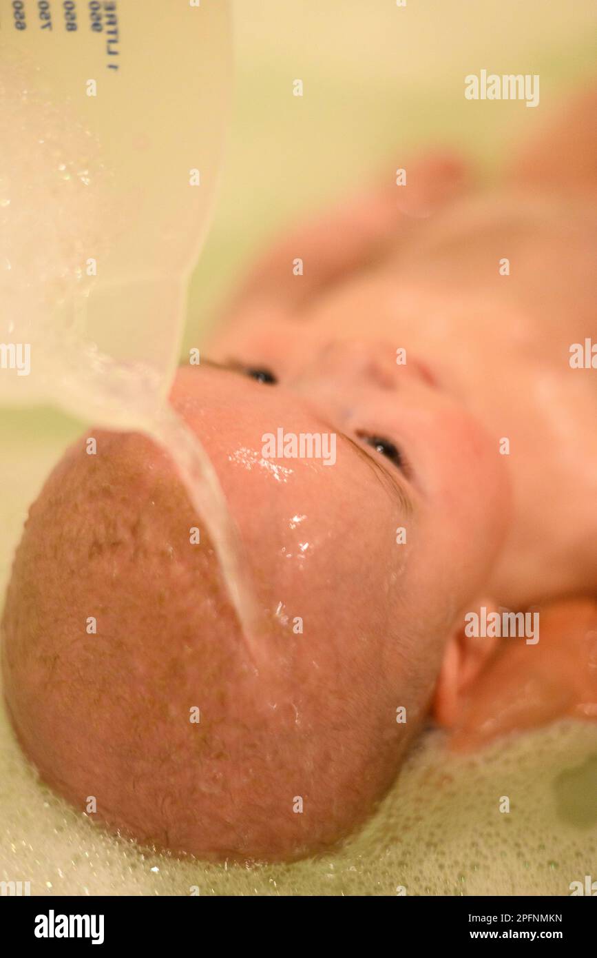 Ein Baby in der Badewanne, das sich die Haare wäscht Stockfoto