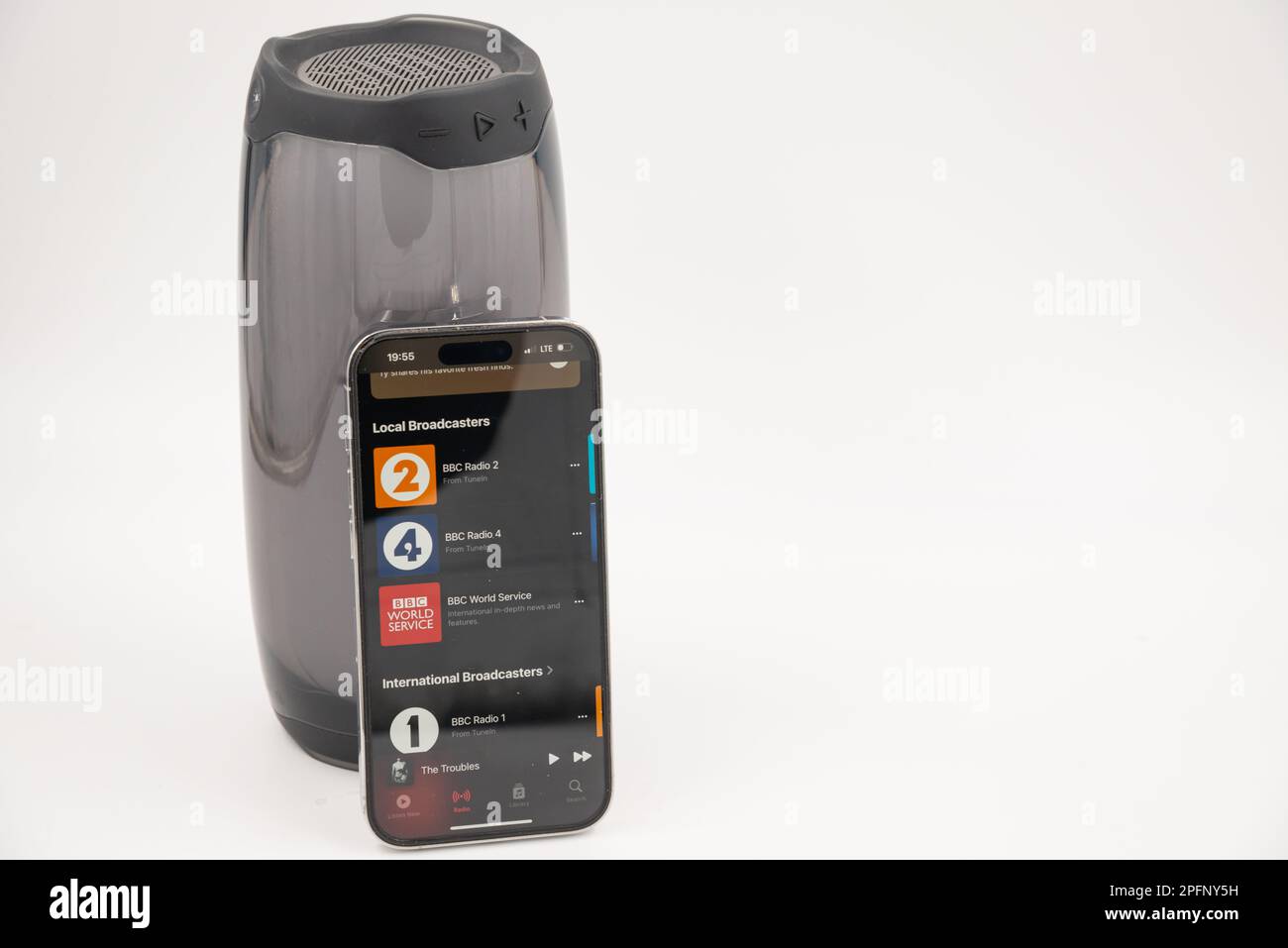 Riga, Lettland - 15. März 2023: Apple Music App auf iPhone vor dem Smart Speaker. Stockfoto