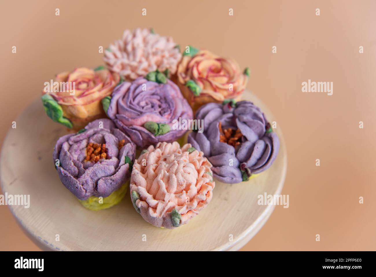 Auf einem runden Holzhintergrund liegen natürliche Marshmallows in Form von Blumen. Süße Desserts ohne Zucker. Kreative Backwaren. Kopierraum, m Stockfoto