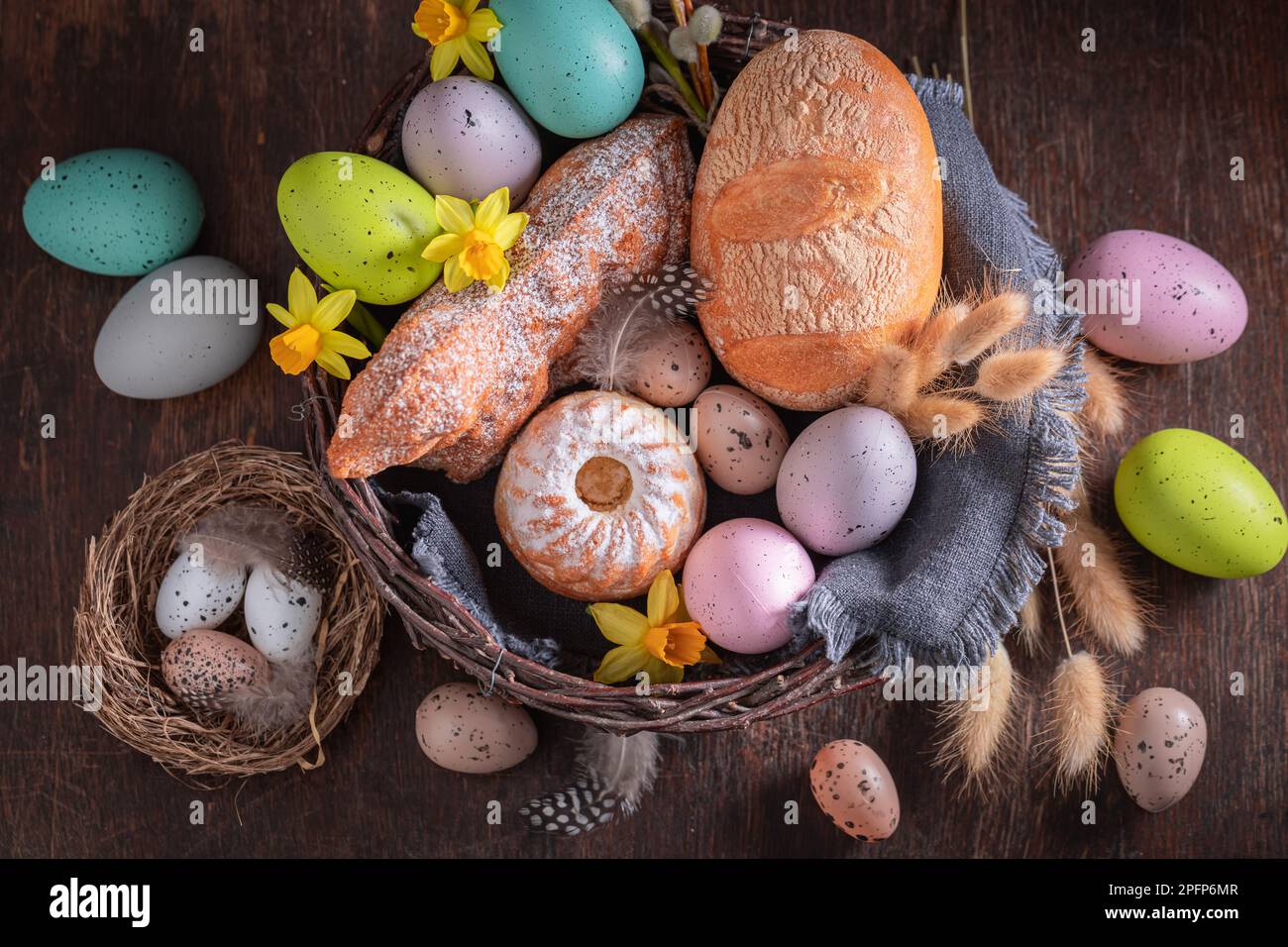 Farbenfroher Osterkorb als Tradition am Heiligen Sonntag in Ostern. Kuchen, Katzenfutter und Ostereier zu Ostern. Stockfoto