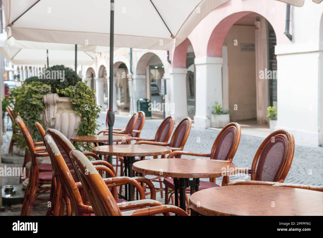 Gemütliches Café mit Holzstühlen an der italienischen Straße. Urlaub in Italien. Typisch italienische Szene Stockfoto