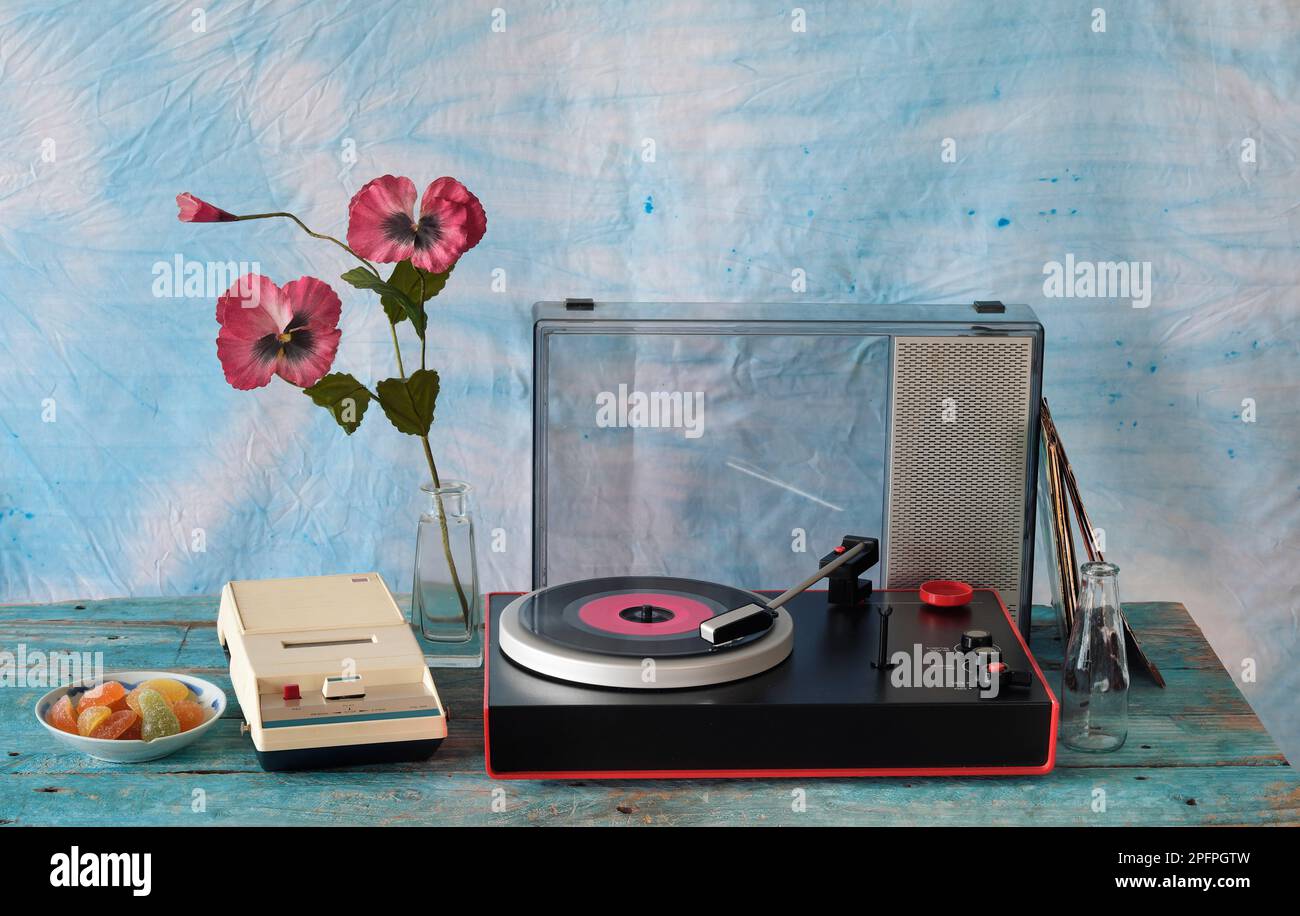 Klassischer Plattenspieler mit violetter Schallplatte, Lautsprecher und altem Kassettenrekorder, Stilleben in den 70er Jahren Stockfoto
