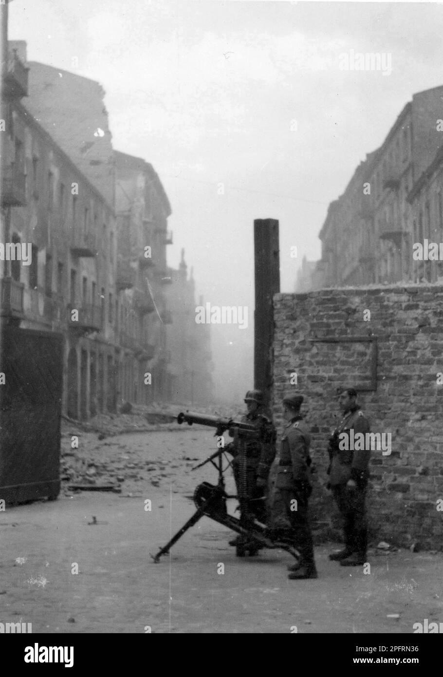 Im Januar 1943 kamen die nazis an, um die Juden des Warschauer Ghettos zu verhaften. Die Juden, die entschlossen waren, es zu bekämpfen, nahmen es mit selbstgemachten und primitiven Waffen auf die SS abgesehen. Die Verteidiger wurden hingerichtet oder deportiert, und das Ghetto-Gebiet wurde systematisch abgerissen. Der nazi-Führer Jürgen Stroop veröffentlichte ein Buch, um seinen Sieg zu feiern. Dieses Buch, bekannt als Sroop-Bericht, wurde von der Staatsanwaltschaft in Nürnberg benutzt. Dieses Ereignis ist wie der Ghetto-Aufstand. Dieses Bild zeigt Wachen der deutschen Polizei mit schwerem Maschinengewehr am Tor zum Ghetto. Stockfoto