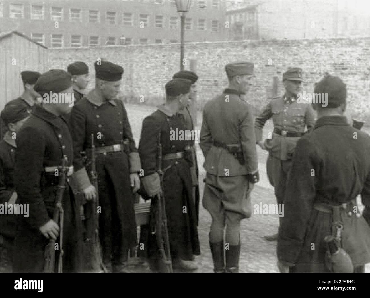 Im Januar 1943 kamen die nazis an, um die Juden des Warschauer Ghettos zu verhaften. Die Juden, die entschlossen waren, es zu bekämpfen, nahmen es mit selbstgemachten und primitiven Waffen auf die SS abgesehen. Die Verteidiger wurden hingerichtet oder deportiert, und das Ghetto-Gebiet wurde systematisch abgerissen. Dieses Ereignis ist bekannt als Ghetto-Aufstand. Dieses Bild zeigt den Waffen-SS-Führer Jürgen Stroop und ausländische Kämpfer während des Ghetto-Aufstands in Warschau. Dieses Bild stammt aus der deutschen Fotoaufzeichnung des Ereignisses, bekannt als Stroop-Bericht. Stockfoto