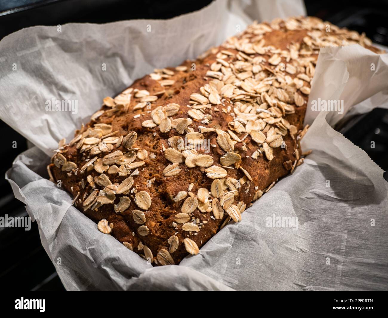 Hausgemachtes Brot mit Hafer auf einem karierten Leinentuch. Stockfoto