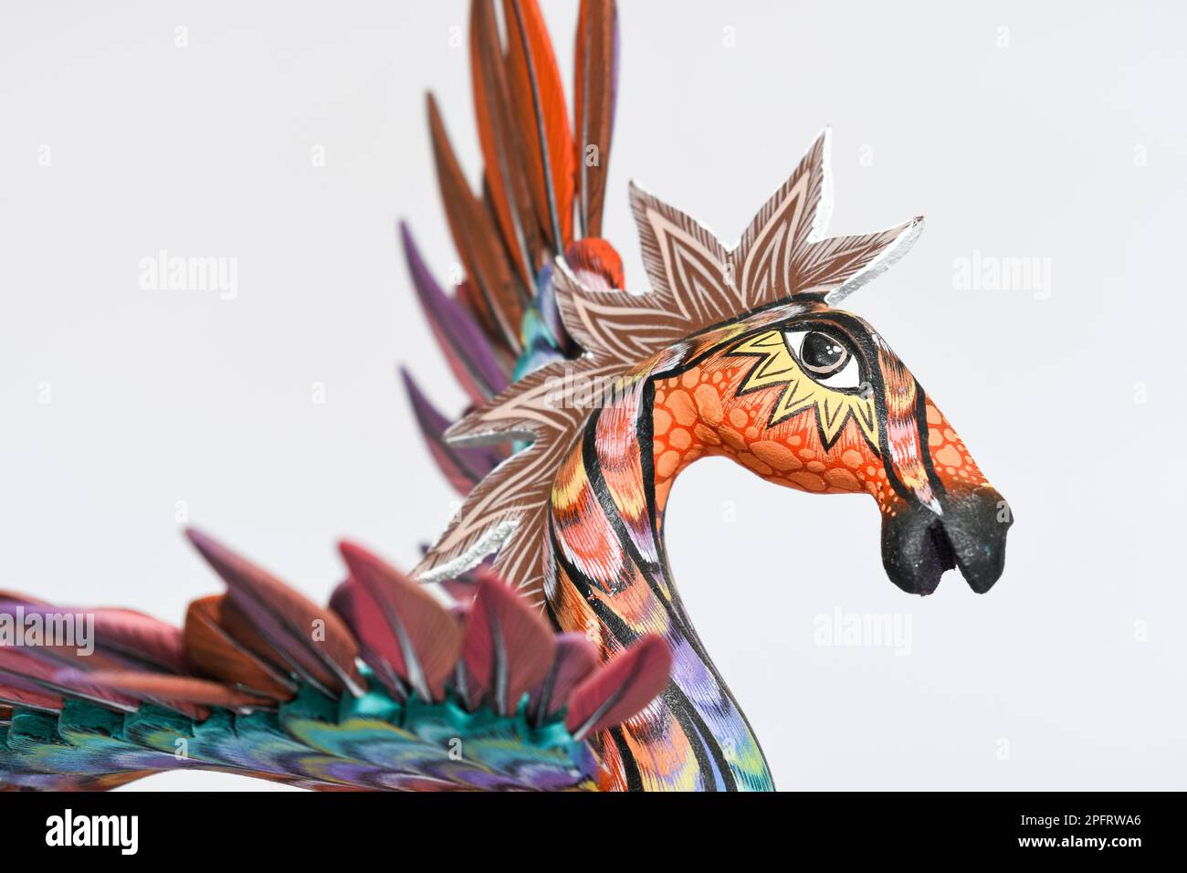 Farbenfroher Alebrije. Mexikanisches handbemaltetes Holzhandwerk in Form eines Pferdes mit Flügeln auf weißem Hintergrund. Oaxaca, Mexiko. Stockfoto