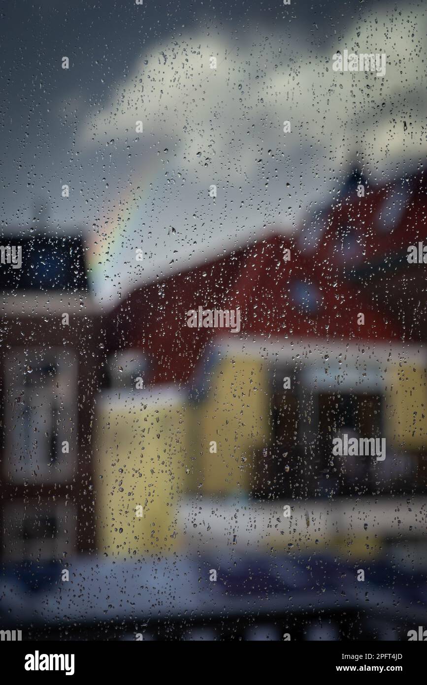 Regentropfen auf einer Fensterscheibe, Fensterregen, verschwommene Stadt, Regen auf Glas. Stockfoto
