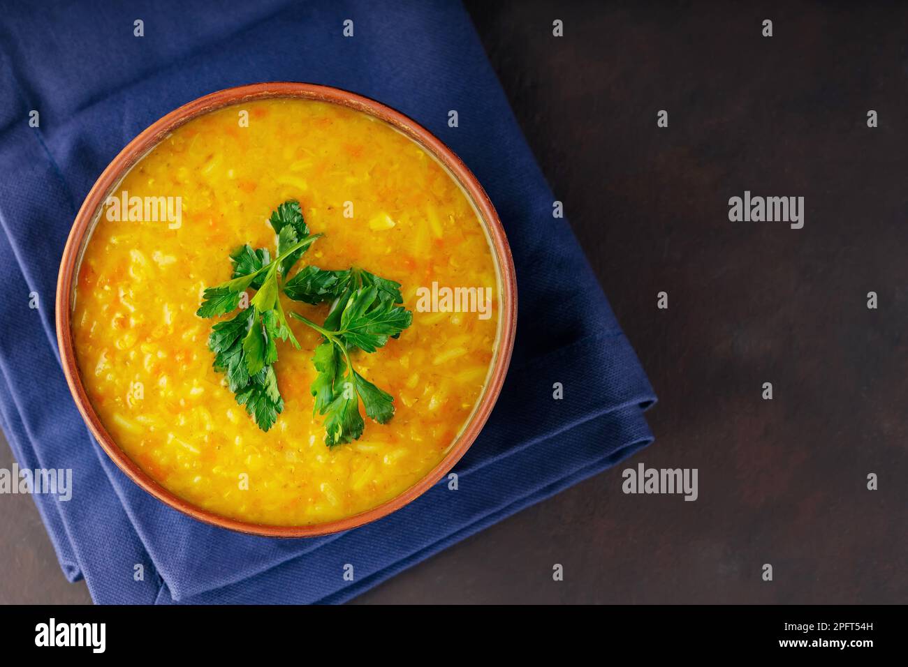 Rote Linsensuppe auf dunkelbraunem Hintergrund. Traditionelle libanesische oder arabische Linsen und würzige Gemüsesuppe. Speicherplatz kopieren Stockfoto