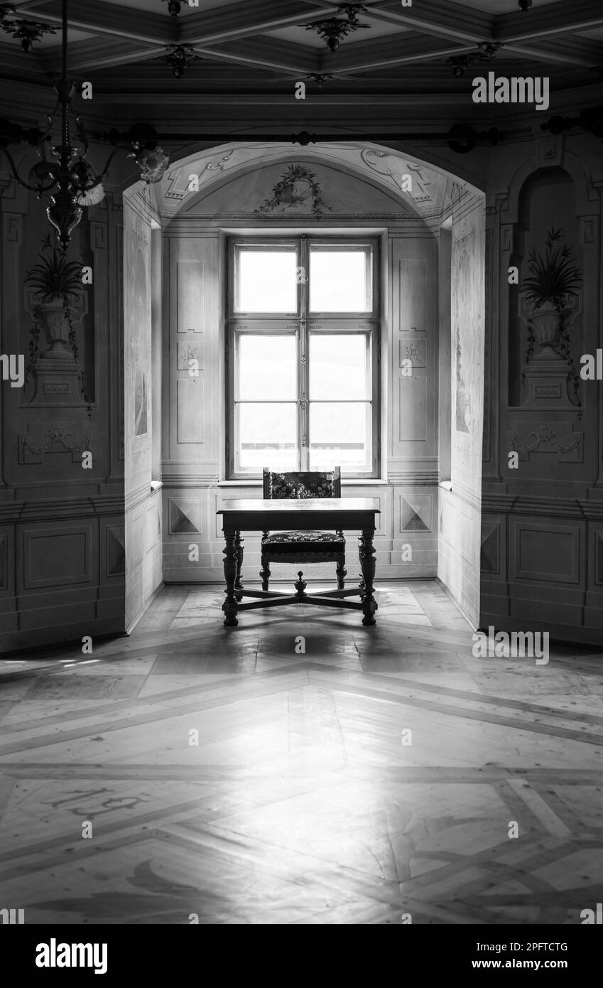 Ein Solitär-Stuhl und -Tisch in einem großen Raum der Burg Savoia, Gebäude im typischen Walsen-Architekturstil Stockfoto