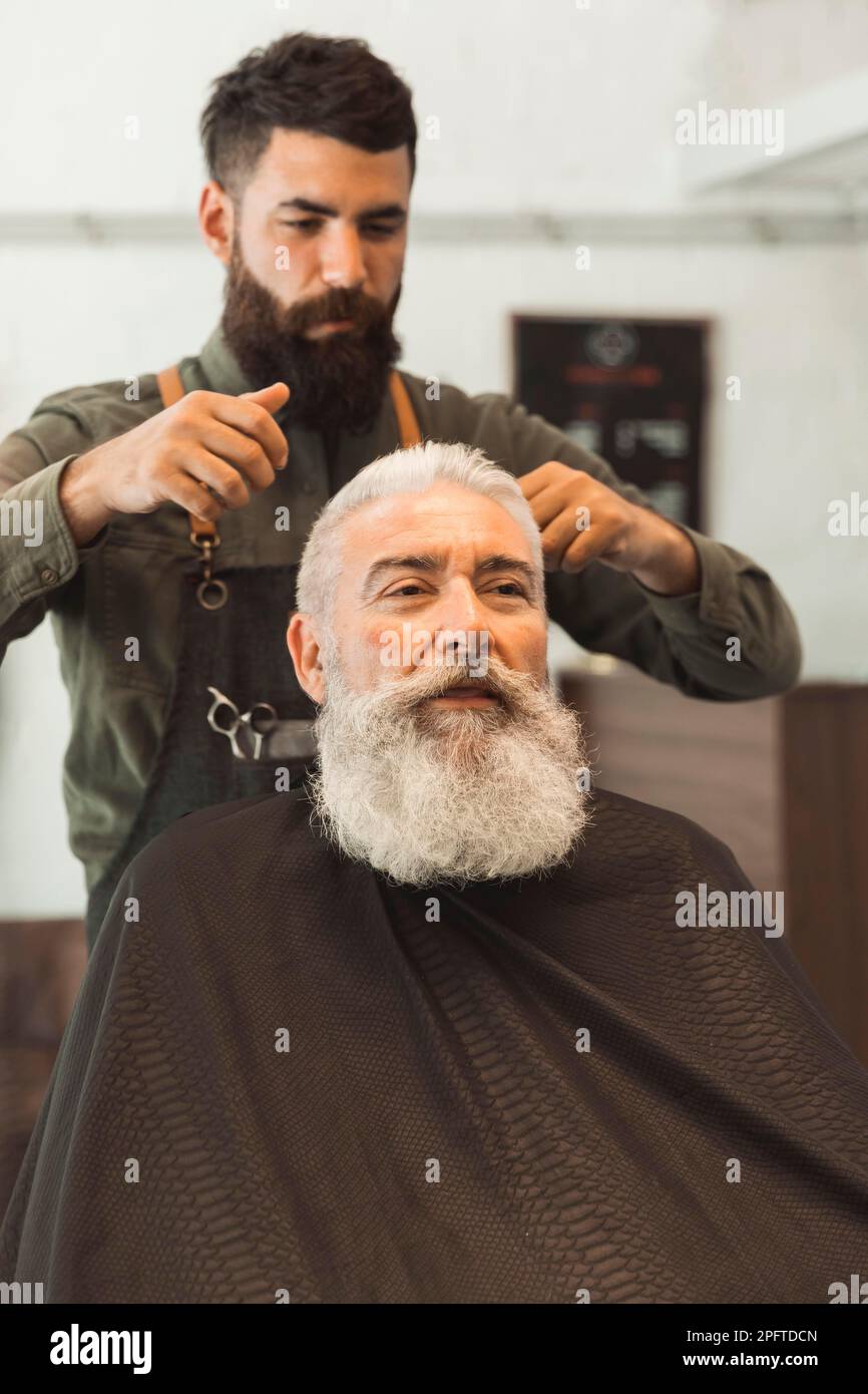 Ein alter Kunde bekommt einen Friseursalon Stockfoto