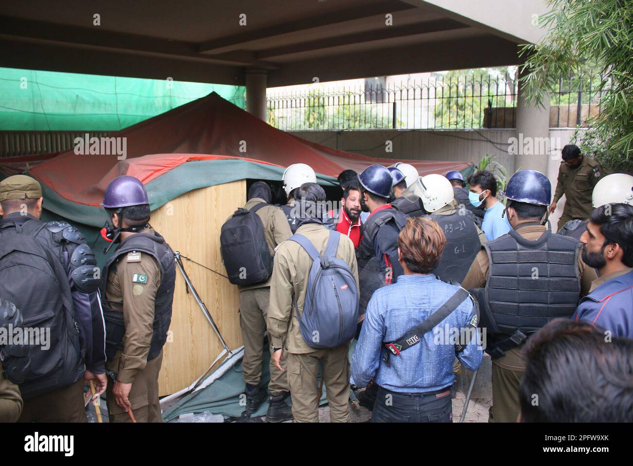 Lahore, Punjab, Pakistan. 18. März 2023. Der ehemalige Premierminister Imran Khan ist von seinen Anhängern umgeben, wenn er von seinem Wohnsitz in Lahore aus nach Islamabad abreist. Ein oberstes pakistanisches Gericht hat am Freitag einen Haftbefehl für Khan ausgesetzt, wodurch ihm ein Aufschub gewährt wurde, nach Islamabad zu reisen und sich einer Anklage in einem Schmuggelverfahren zu stellen, ohne inhaftiert zu werden. Polizeibeamter beteiligt sich an der Operation im Wohnsitz des ehemaligen pakistanischen Premierministers im Zaman-Park. (Kreditbild: © Rana Sajid Hussain/Pacific Press via ZUMA Press Wire) NUR REDAKTIONELLE VERWENDUNG! Nicht für den kommerziellen GEBRAUCH! Stockfoto