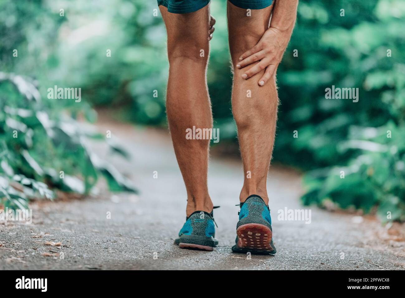 Läufer-Bein-Verletzung schmerzhaftes Bein. Mann massiert schmerzhafte Wadenmuskeln beim Lauftraining im Freien Stockfoto
