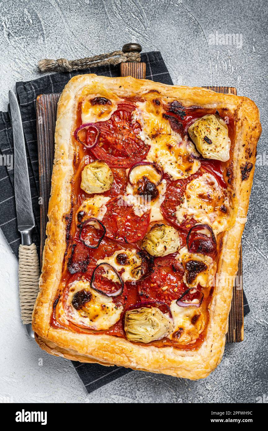 Vegetarische Blätterteigpizza mit Artischocke, Mozzarella, Tomaten und Käse. Weißer Hintergrund. Draufsicht. Stockfoto