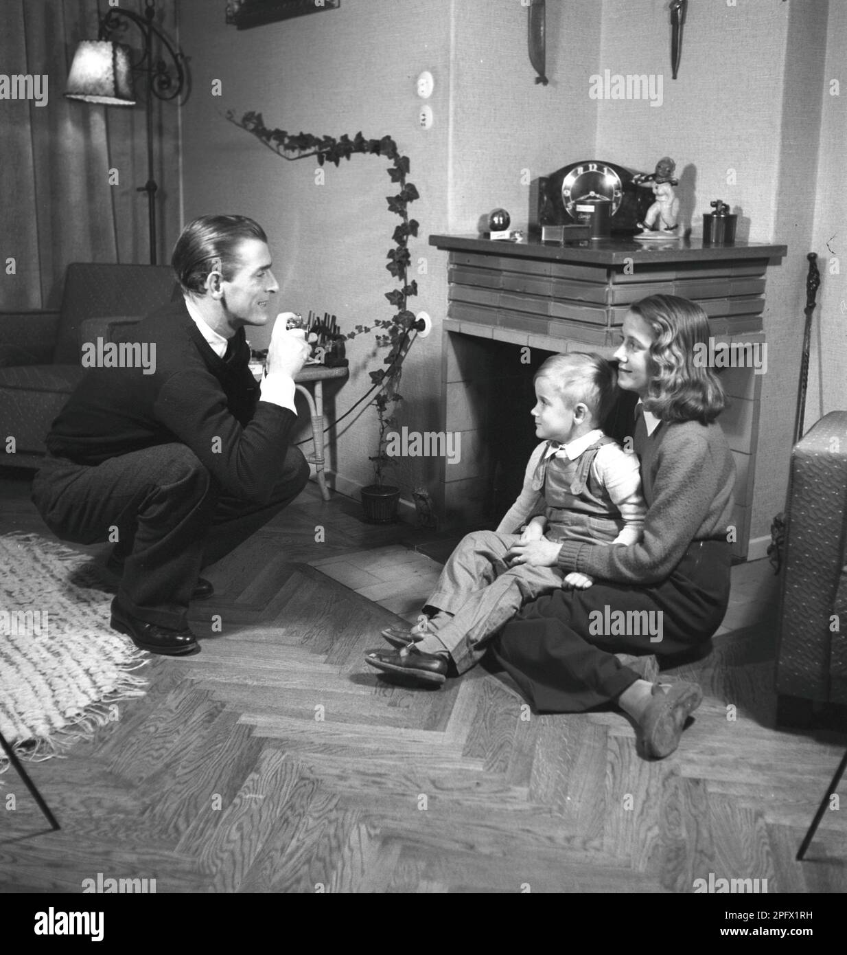 Ein Amateurfotograf in den 1940er Jahren fotografiert seine Frau und seinen Sohn zu Hause. Er ist der schwedische Schauspielersänger Lasse Dahlquist. Schweden 1943. Kristoffersson Ref. B27-4 Stockfoto