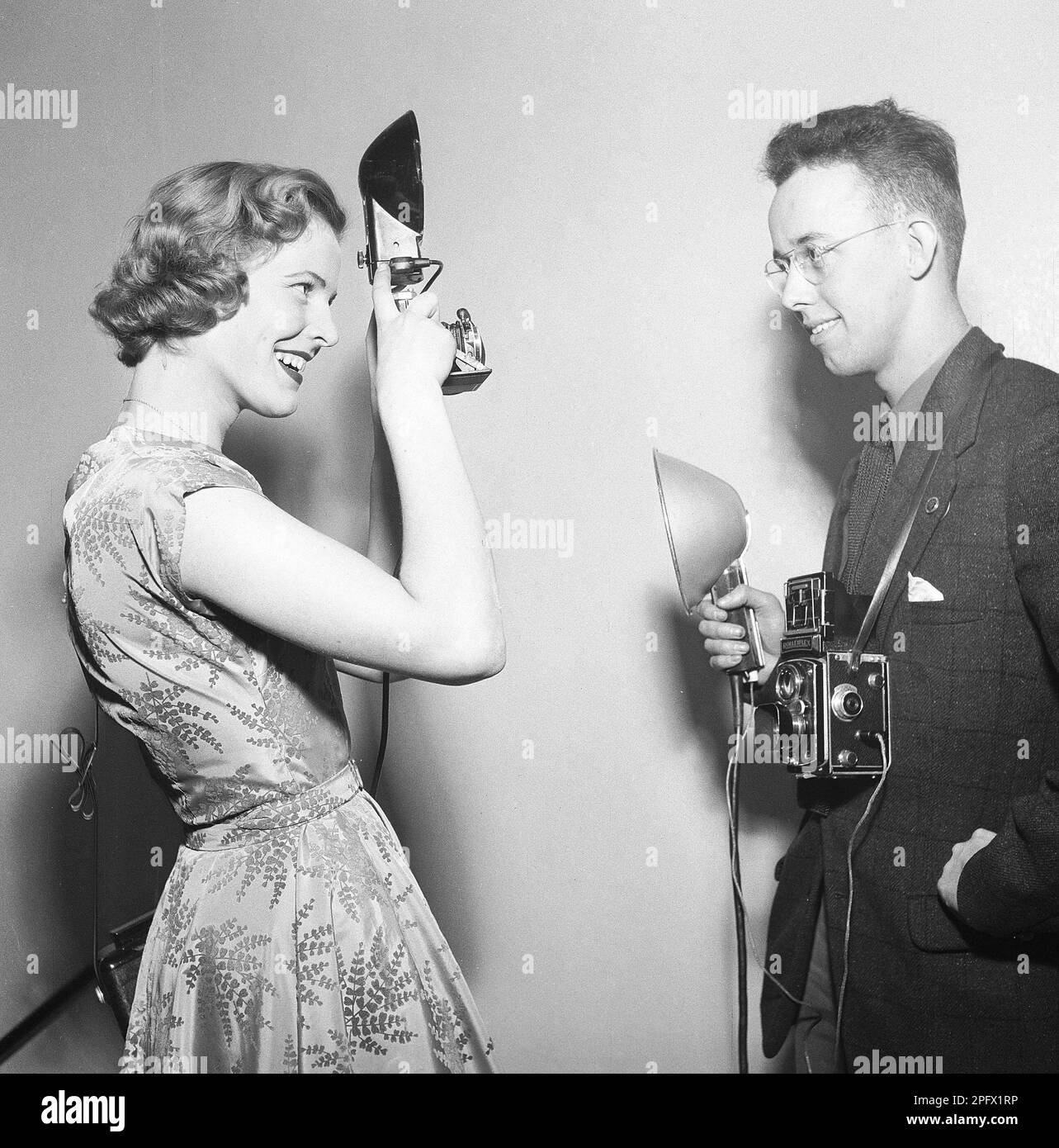Fotografen in den 1950er. Eine junge Frau fotografiert einen anderen Fotografen. Seine Kamera ist ein Rolleiflex von der deutschen Firma Rollei für 60-mm-Filme. Schweden 1956. Foto Kristoffersson Ref. BX37-10 Stockfoto