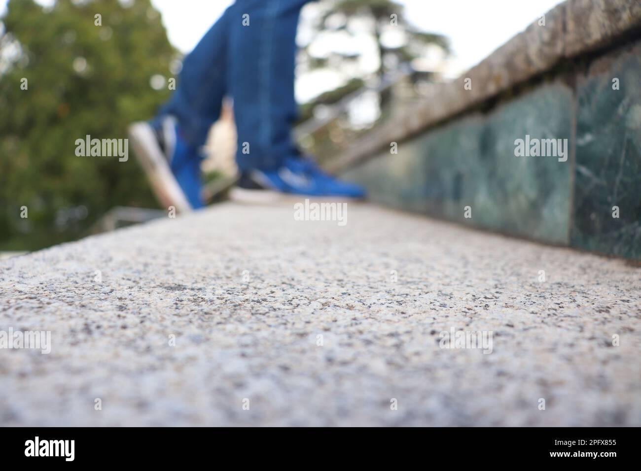 Eine Person mit blauen Jeans und Schuhen, die die Treppe hinaufging, verschwommen Stockfoto