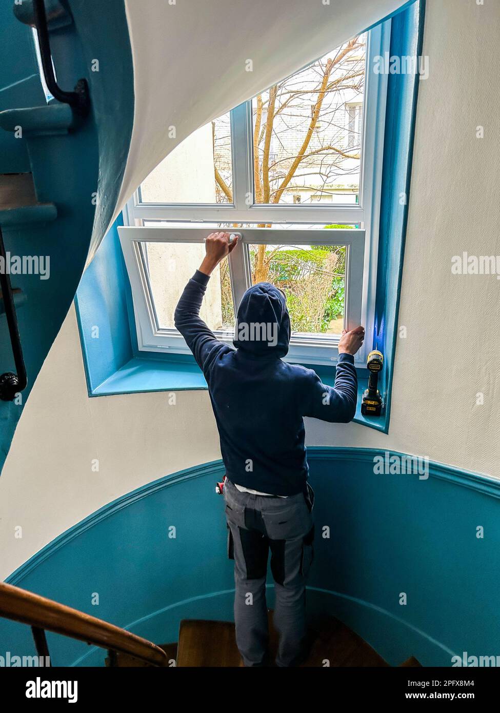 Paris, Frankreich, französischer Arbeiter, der neue Doppelverglasungsfenster im Wohnungsgebäude Coop Stairway installiert Stockfoto