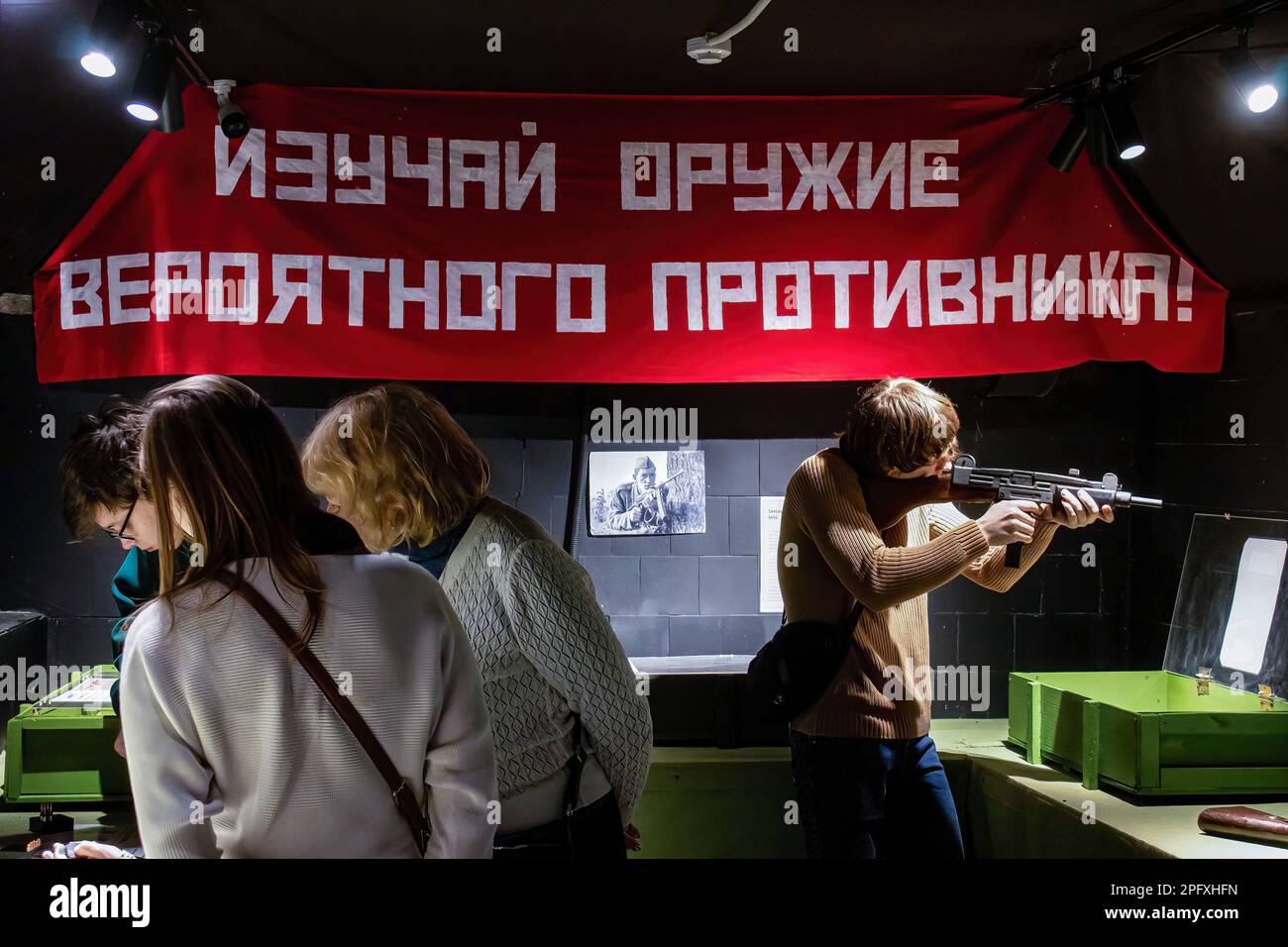 Moskau, Russland. 18. März 2023. Ein Teenager studiert Uzi, eine in Israel entwickelte Maschinenpistole, im interaktiven Museum Guns Dungeon in Moskau. Der Text auf dem Poster oben, auf dem steht: ìStudy die Waffen eines potenziellen Feindes!î (Foto: Vlad Karkov/SOPA Images/Sipa USA) Guthaben: SIPA USA/Alamy Live News Stockfoto