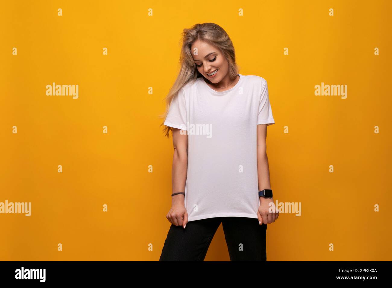 Junge Dame in einem weißen T-Shirt-Mocap auf gelbem Hintergrund Stockfoto