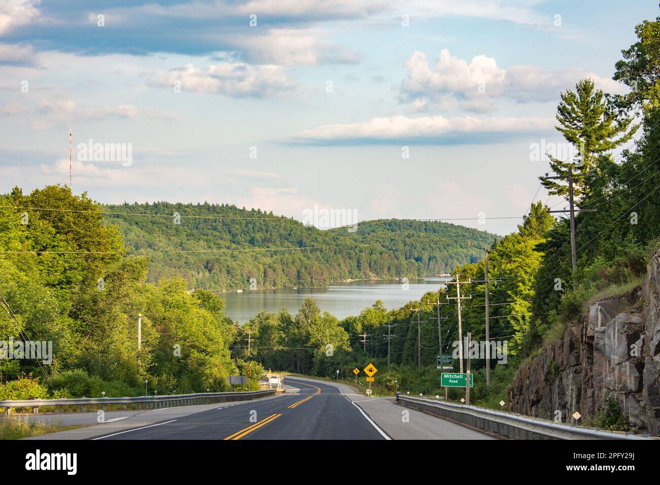 Die Straße zu einem großen See, umgeben von Wäldern Stockfoto