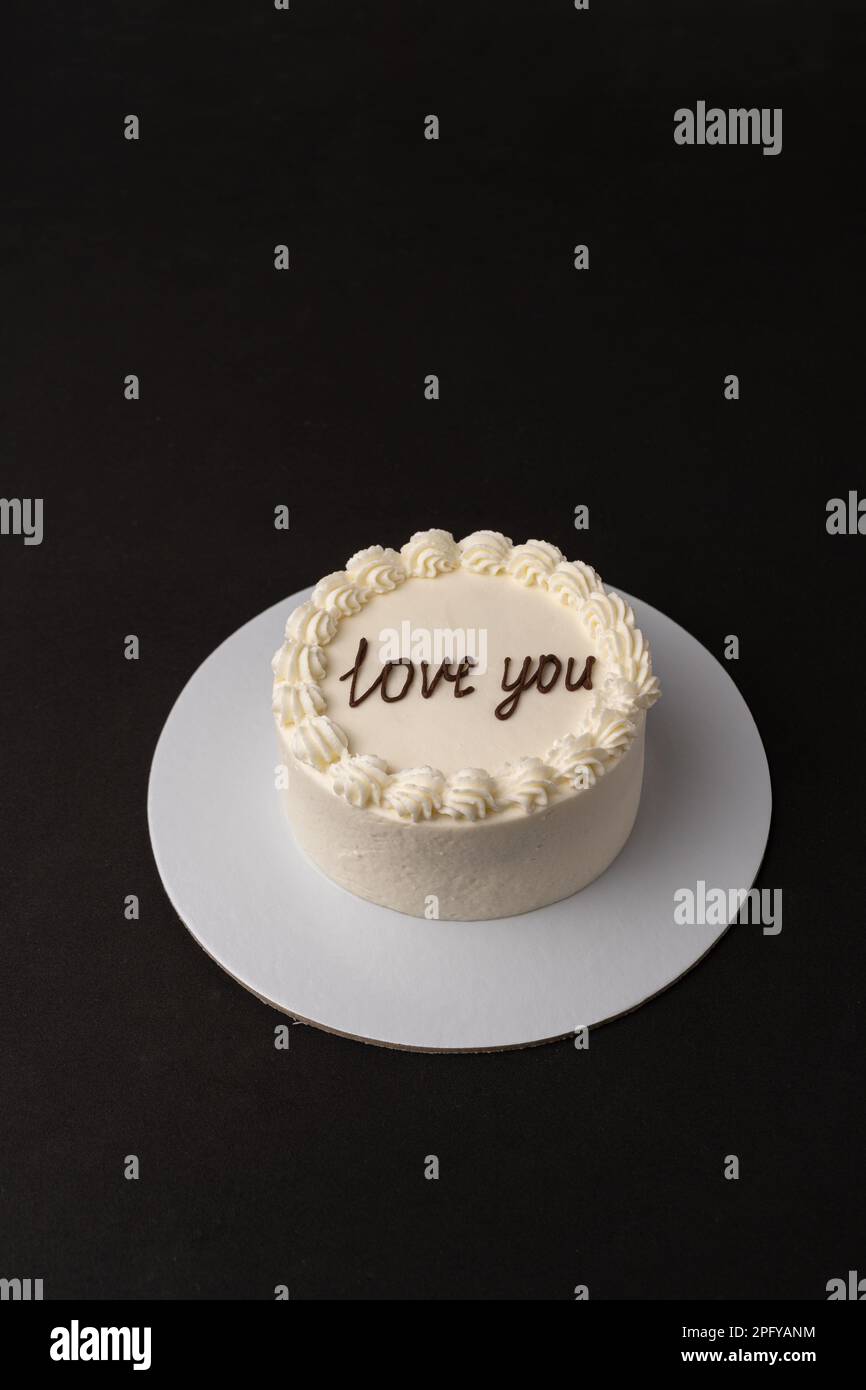 Kleiner weißer Kuchen auf schwarzem Hintergrund Stockfoto