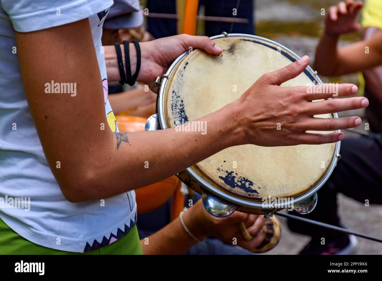 Details der Hand eines Musikers, der während einer Capoeira-Vorstellung in den Straßen Brasiliens Tamburin spielt Stockfoto