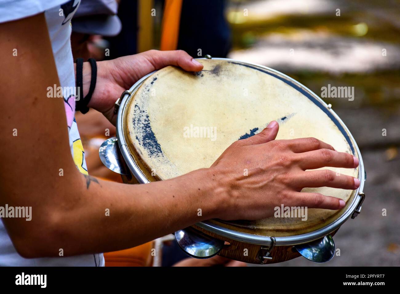 Detail eines Musikers, der Tamburin spielt, während einer Samba-Vorstellung auf dem Karneval in den Straßen Brasiliens Stockfoto