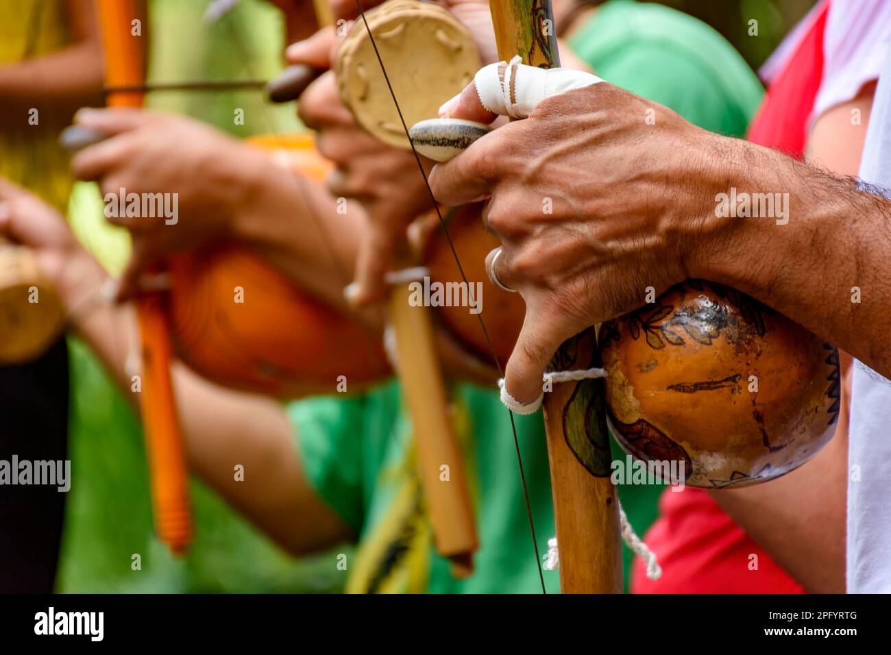 Hände eines Musikers, der während einer Capoeira-Vorstellung in den Straßen Brasiliens ein Afro-brasilianisches Schlaginstrument namens Berimbau spielte Stockfoto