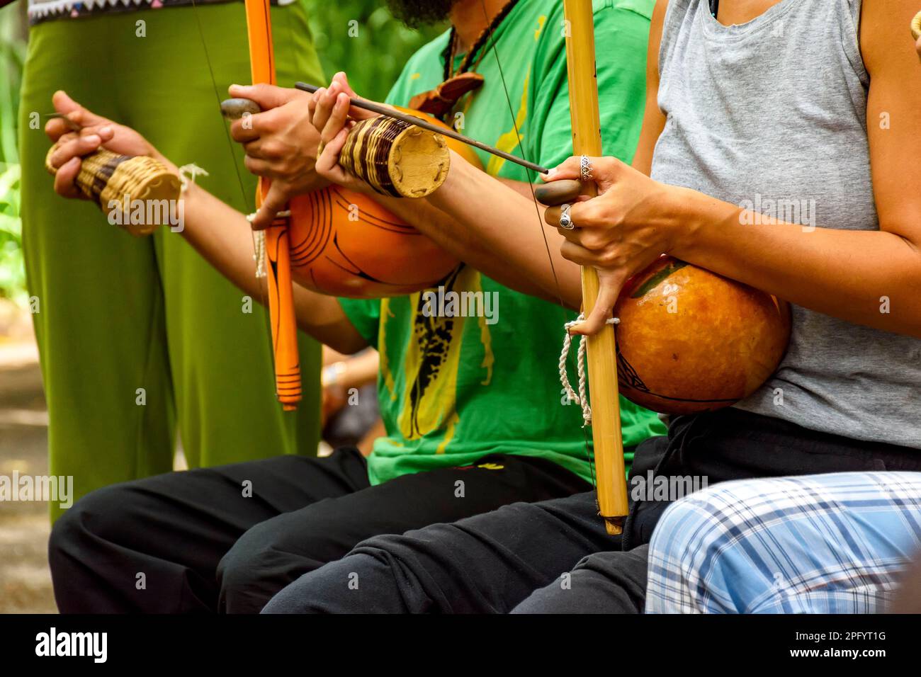 Musiker, die während einer Capoeira-Aufführung in den Straßen Brasiliens die Afro-brasilianischen Perkussion-Musikinstrumente Berimbau spielen Stockfoto
