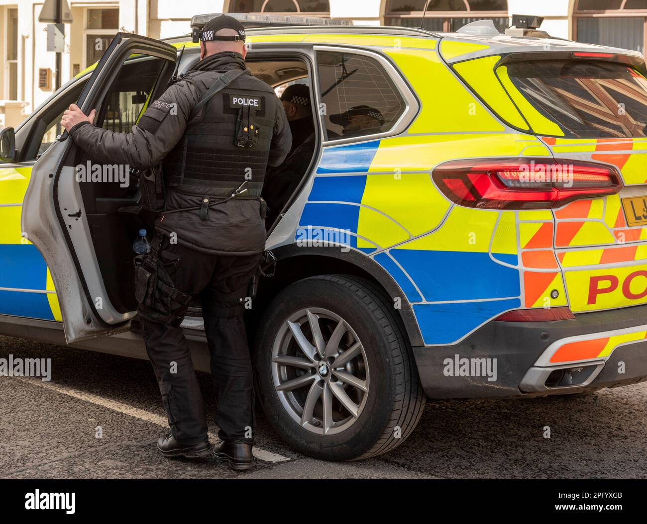 Windsor, Berkshire, England, Großbritannien. 2023. Bewaffneter Polizist steigt in einen Streifenwagen. Stockfoto