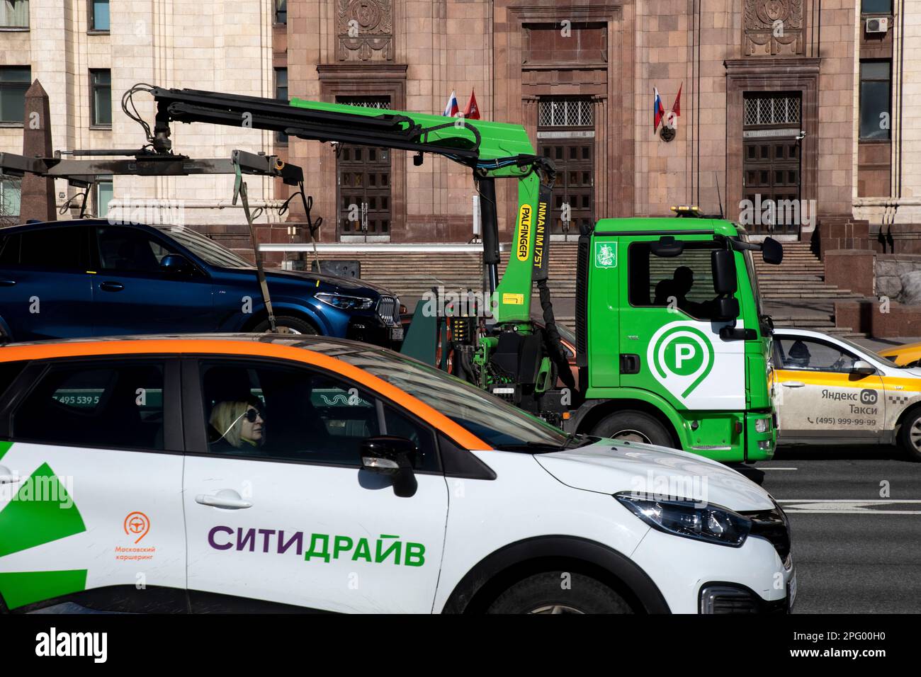Moskau, Russland. 19. März 2023. Ein städtischer Abschleppwagen und ein Citydrive Carsharing Service Car fahren auf einer Straße im Zentrum von Moskau, Russland Stockfoto
