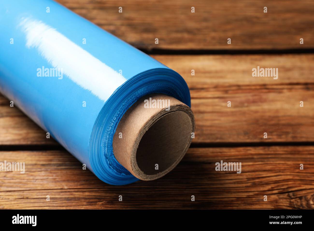 Rolle Stretchfolie aus Kunststoff auf Holztisch, Nahaufnahme Stockfoto