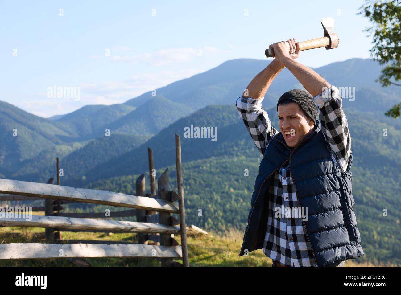 Hübscher Mann, der Axt in den Bergen schwingt, Platz für Text Stockfoto Hübscher Mann, der Axt in den Bergen schwingt, Platz für Text Stockfoto