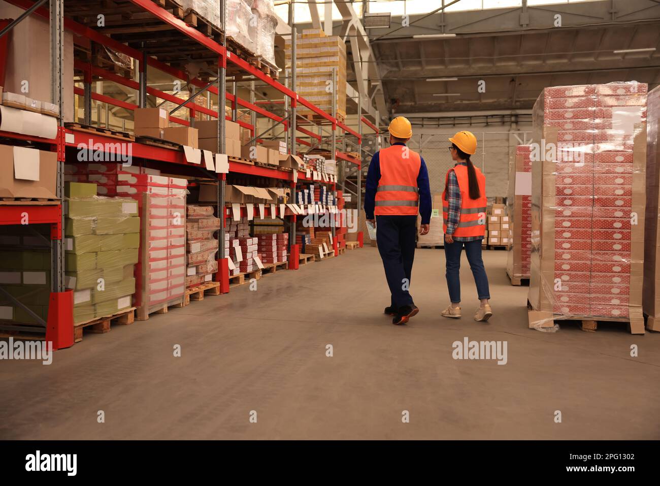 Manager und Arbeiter im Lager, Rückansicht. Logistikzentrum Stockfoto