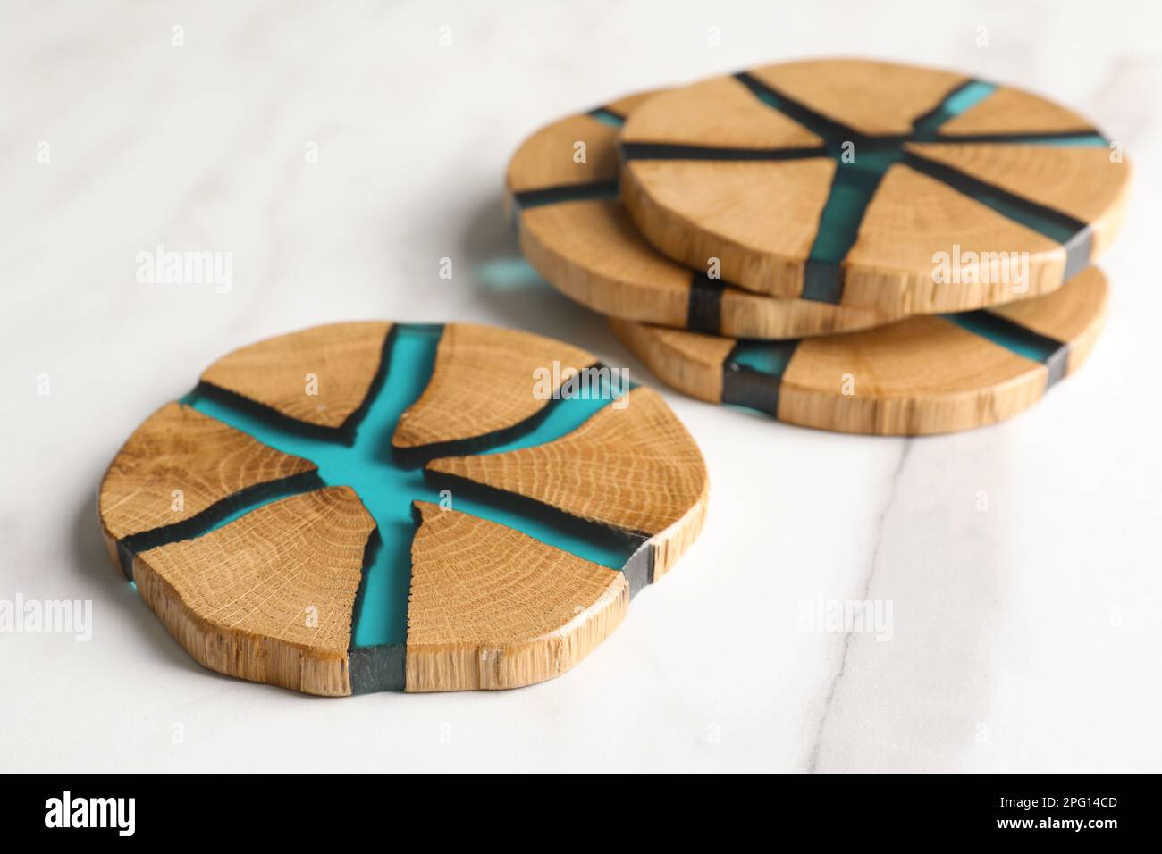 Stilvolle Untersetzer aus Holzbechern auf einem weißen Tisch Stockfoto