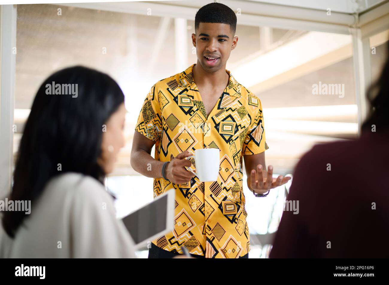 Ich habe mir eine tolle neue Strategie ausgedacht. Ein junger Geschäftsmann, der mit seinen Kollegen in einem Büro spricht. Stockfoto