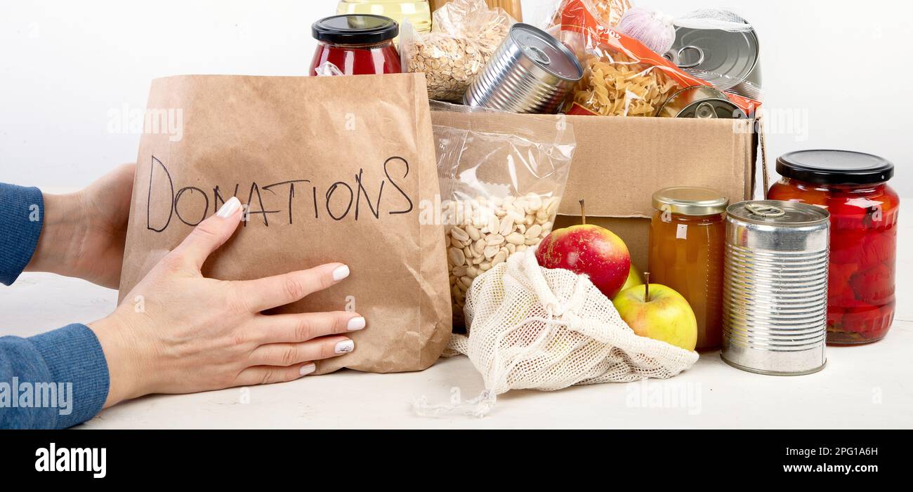 Lebensmittelspendenbox mit verschiedenen Produkten auf hellem Hintergrund, Draufsicht. Lebensmittelspenden oder Lieferkonzept. Stockfoto
