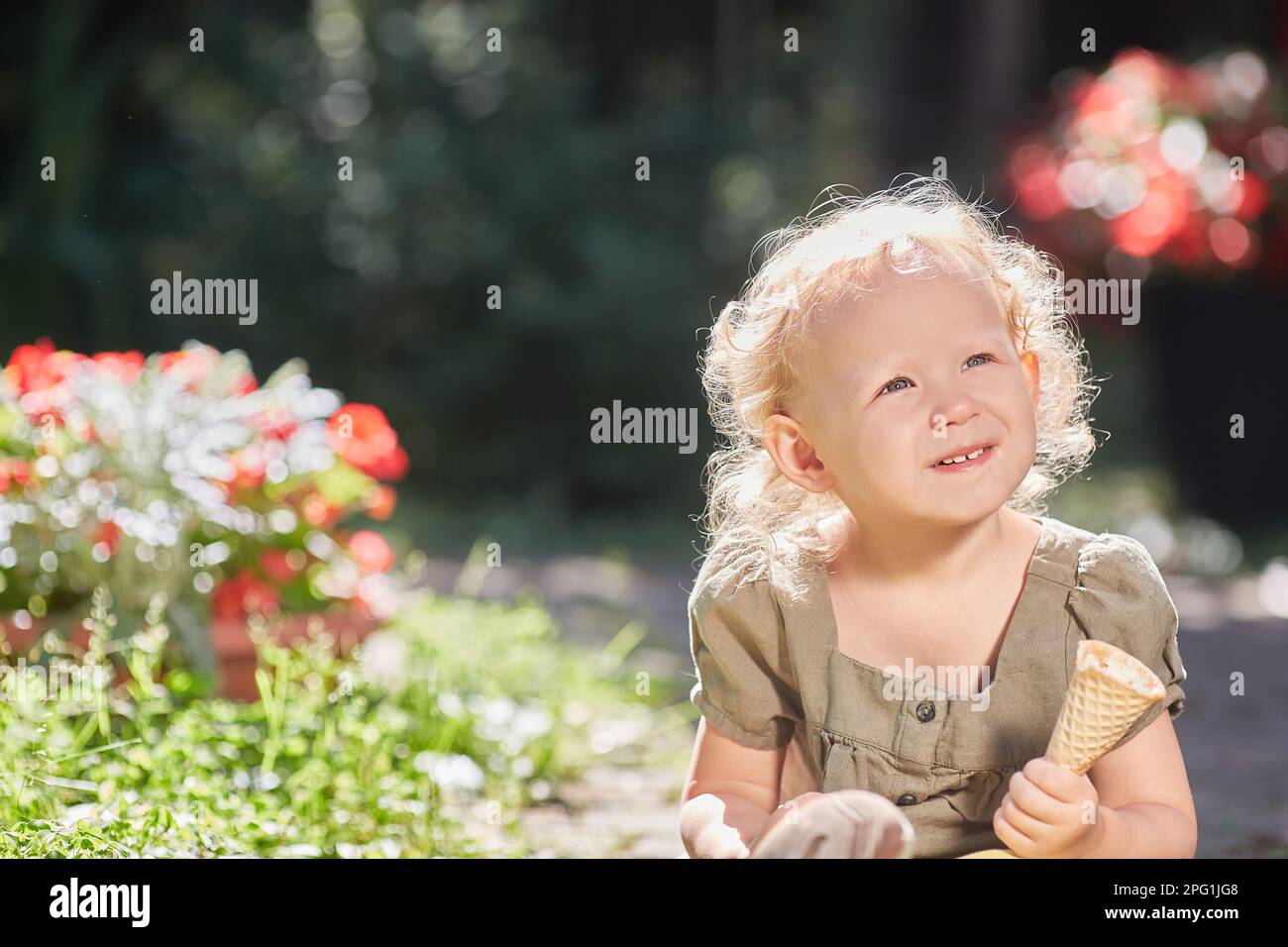 Ein fröhliches Kind mit Eiscreme in den Händen. In der Sonne an einem heißen Sommertag. Stockfoto